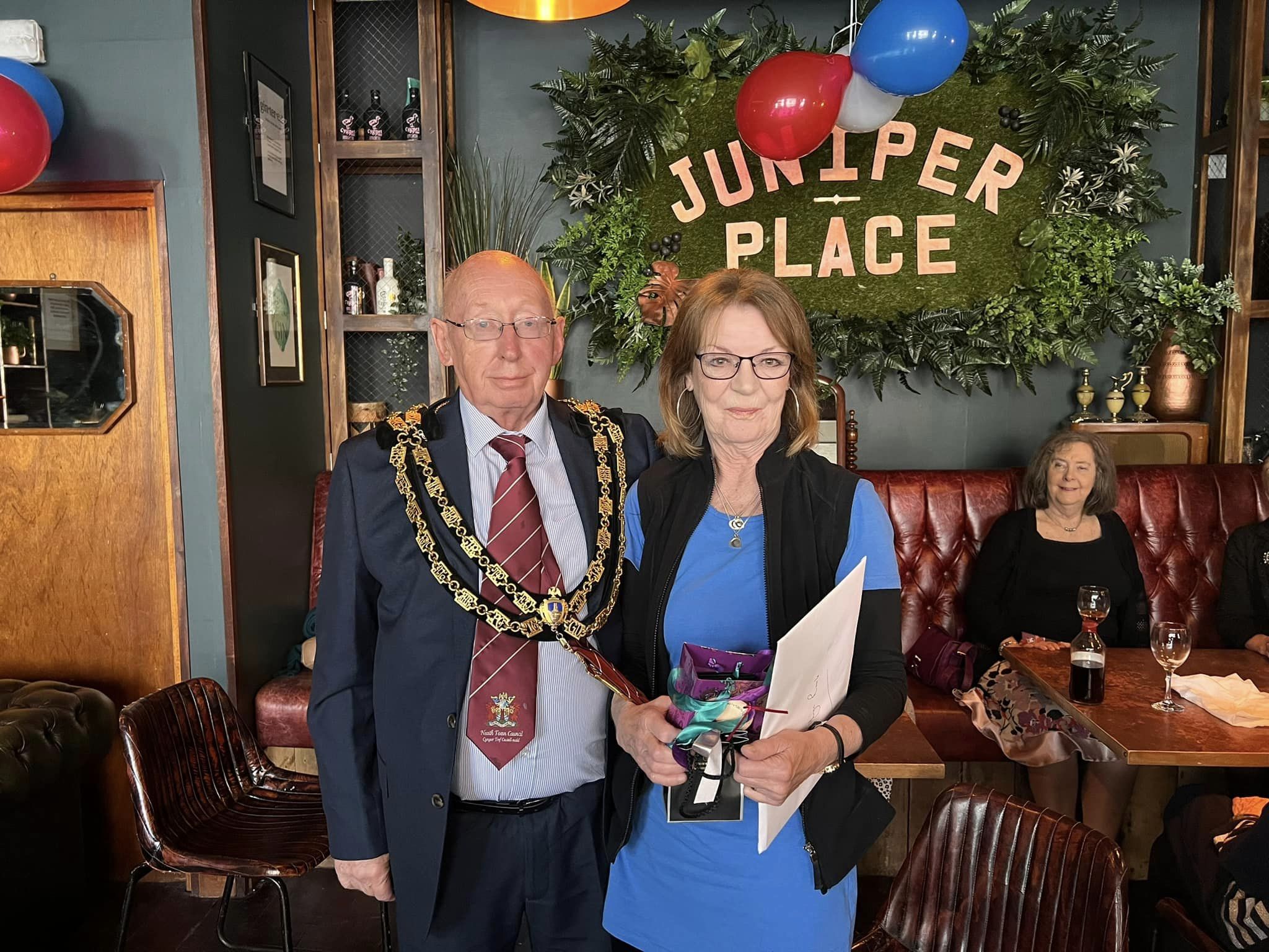 The Mayor and Lyn Rawle holding her gift in Juniper Place at her retirement party