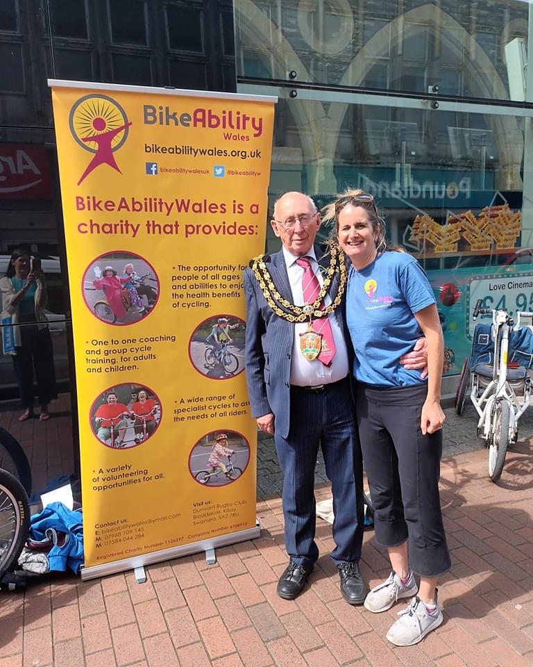The Mayor with a lady, standing outside the Gwyn Hall in front of a Bikeability banner